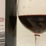 video Știrea ta: vin roșu în sticlă, alb pe etichetă.