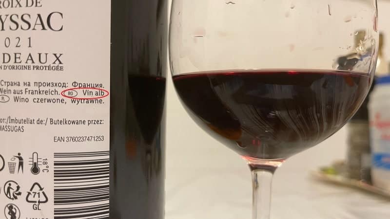 video Știrea ta: vin roșu în sticlă, alb pe etichetă.